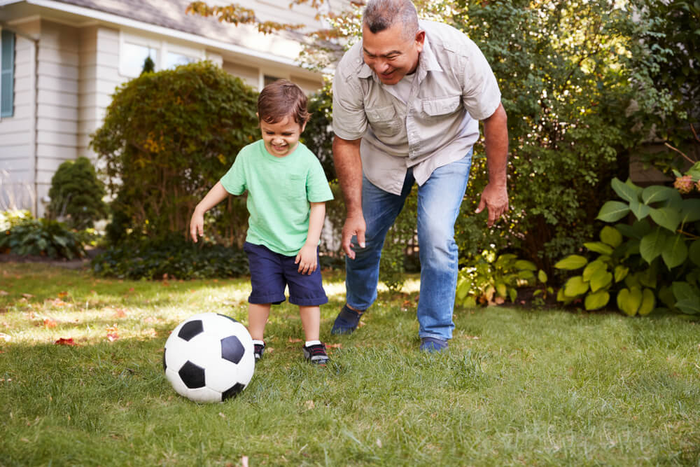 Grandfather Playing Soccer In Garden