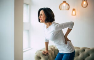patient struggling to stand up due to severe lower back pain