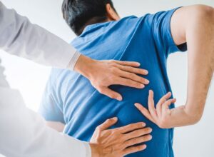 Doctor providing back pain treatment and physical examination at MVM Health clinic