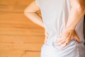 A person holding lower back and hip in pain