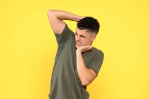 man is holding his neck suffering from shoulder Popping with Pain