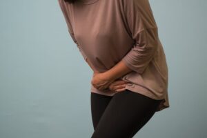 Woman is holding her stomach she is suffering from Interstitial Cystitis