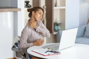 women is suffering from Neck Pain, sitting in her work place