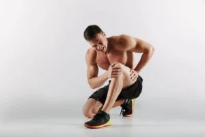 man is sitting on the floor as he is suffering from Knee Pain