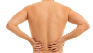 man holding his lower back as he is suffering from Lower Back Pops