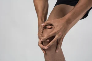 man is holding his knee as he is shuffering form Chronic Pain