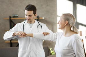 Medical professional assisting an elderly woman with physical therapy exercises
