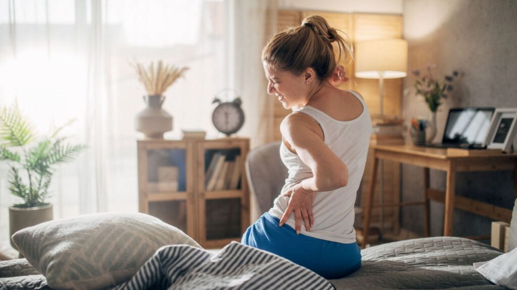 Woman holding lower back experiencing chronic back pain