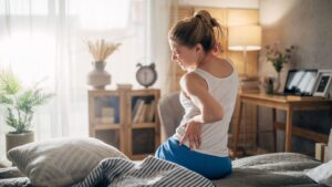 Woman holding lower back experiencing chronic back pain